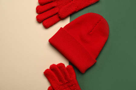 Warm hat and gloves on color background, closeup