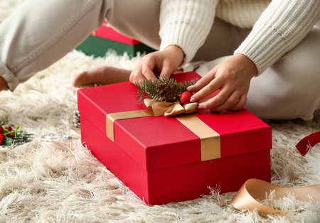 Woman decorating beautiful Christmas gift box at home, closeupの写真素材