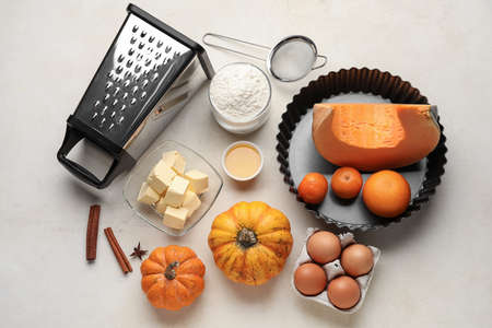 Fresh ingredients for pumpkin pie on white background