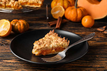 Plate with piece of fresh pumpkin pie on wooden backgroundの写真素材