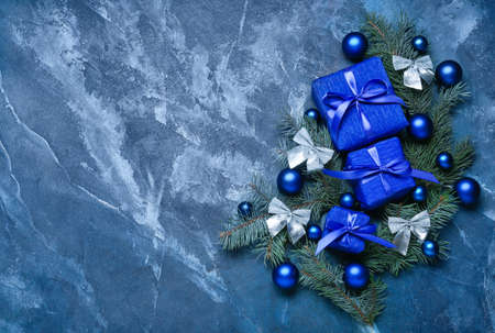 Composition with Christmas gift boxes, fir branches and balls on blue backgroundの写真素材