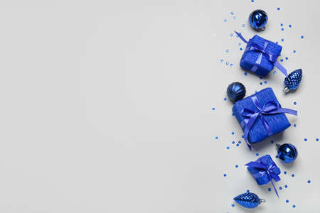 Composition with Christmas gift boxes and balls on light background