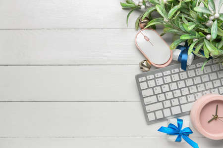 Supplies of office worker and Christmas decor on white wooden background