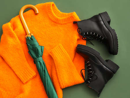 Stylish shoes, sweater and umbrella on green background, closeupの写真素材