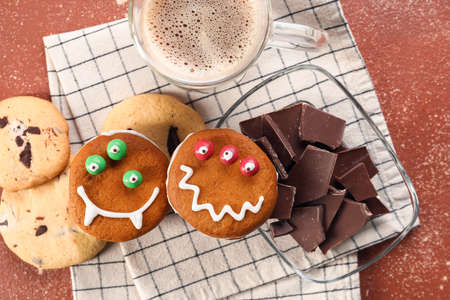 Funny cookies with chocolate and cup of coffee on color background