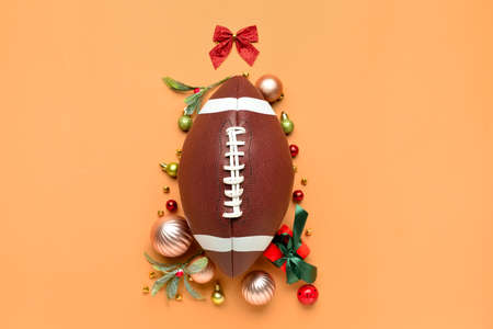 Christmas tree made of rugby ball and decor on color background