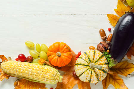 Different healthy food and autumn leaves on light wooden background. harvest festivalの写真素材