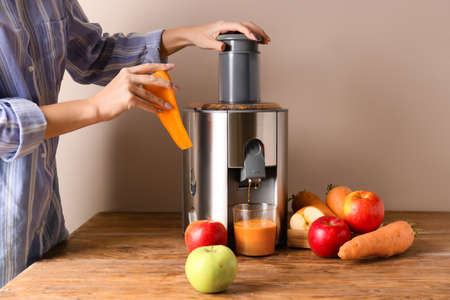 Woman making fresh juice on tableの写真素材