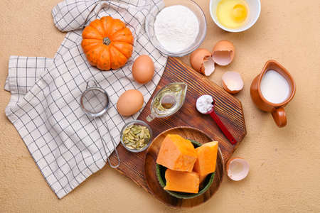 Fresh ingredients for preparing pumpkin pie on beige backgroundの写真素材