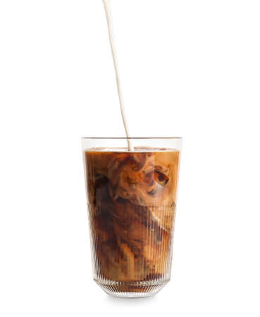 Pouring of milk into glass with iced coffee on white backgroundの写真素材