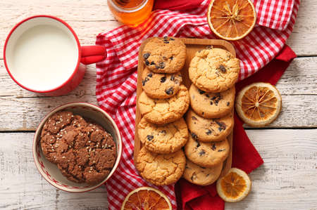 Board and bowl with tasty homemade cookies on white wooden backgroundの写真素材