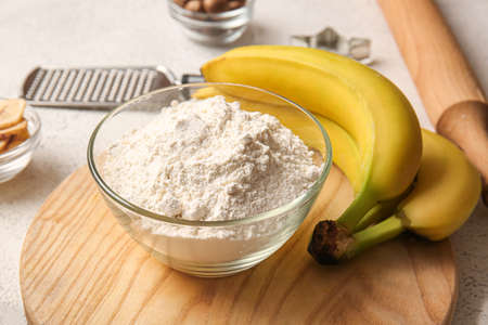 Bowl with flour and bananas for preparing homemade cookies on light backgroundの写真素材