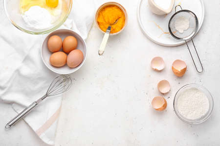 Fresh ingredients for preparing pumpkin pie on light backgroundの写真素材
