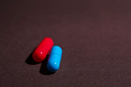 Blue and red pills on dark background. concept of choiceの写真素材