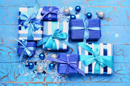 Beautiful Christmas gifts with decor on blue wooden background