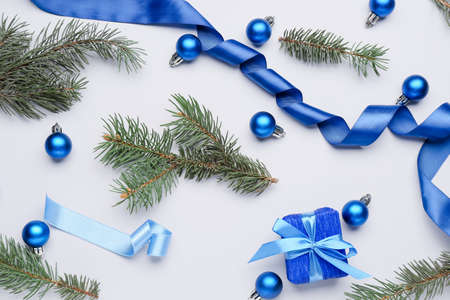 Fir tree branches with beautiful Christmas decor and gift on white backgroundの写真素材