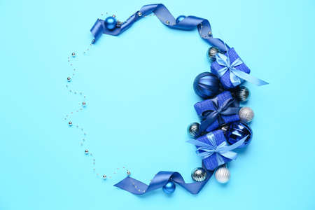 Frame made of beautiful Christmas gifts and decor on blue backgroundの写真素材