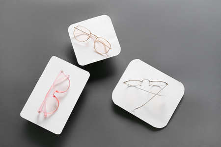 Stylish eyeglasses on gray background