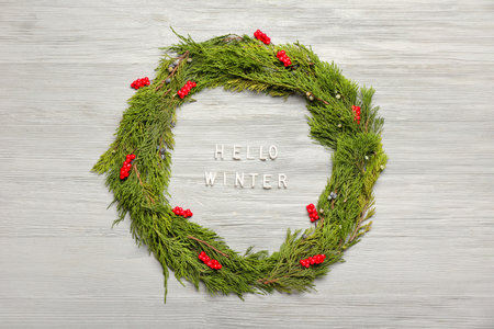 Composition with text HELLO WINTER and coniferous branches on gray wooden backgroundの写真素材
