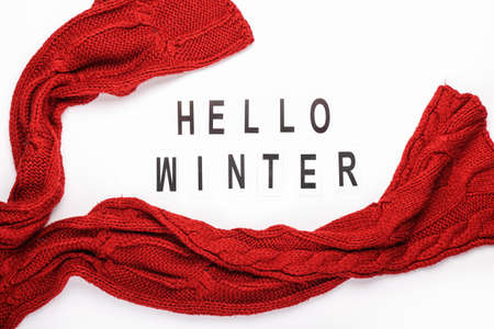 Text HELLO WINTER and knitted scarf on white backgroundの写真素材