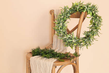 Chair with mistletoe wreath and scarf near color wallの写真素材