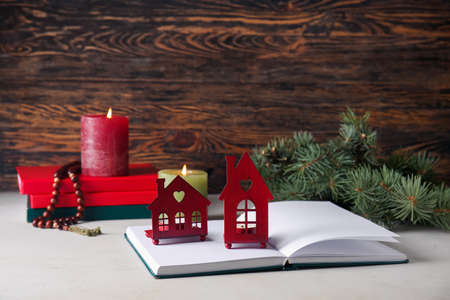 Book with glowing candles on table against wooden background. christmas storyの写真素材