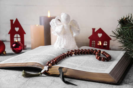 Book with angel toy and beads on table. christmas story