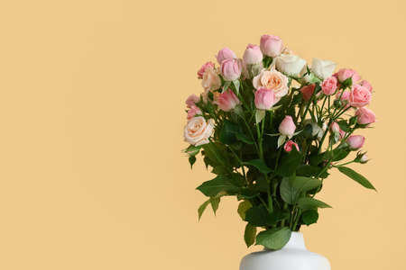Vase with bouquet of beautiful fresh roses on color backgroundの写真素材