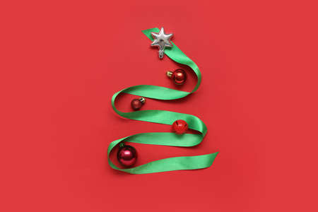 Creative Christmas tree made of decorations on color backgroundの写真素材