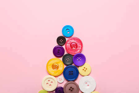 Christmas tree made of buttons on color background