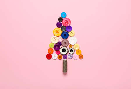 Christmas tree made of buttons and threads on color backgroundの写真素材