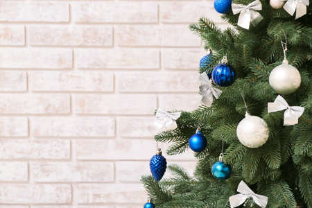 Beautiful Christmas tree with decor on brick background, closeupの写真素材