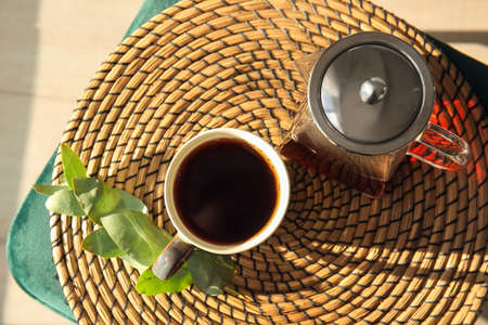 Cup of tasty tea and pot on table in cafe