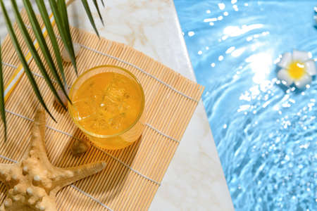Glass of fresh soda near swimming poolの写真素材
