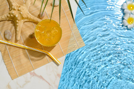 Glass of fresh soda near swimming pool