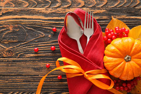 Composition with table setting, pumpkin and autumn leaves on wooden backgroundの写真素材