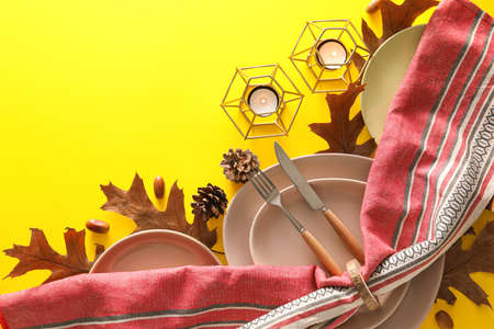 Autumn table setting on yellow background