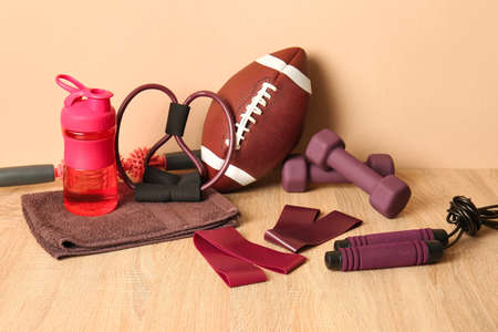 Stylish sport equipment on wooden floor against beige wallの写真素材