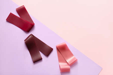 Stylish elastic bands on color background