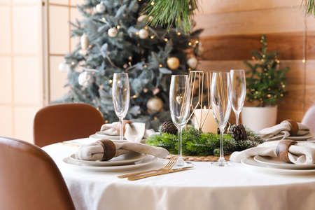 Dining table with beautiful setting for Christmas celebration in festive roomの写真素材