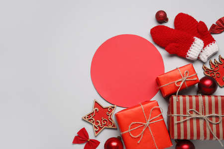 Blank card, gift boxes and Christmas decor on gray background