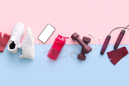 Sports equipment, shoes, mobile phone and earphones on color backgroundの写真素材