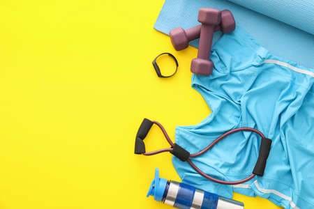 Composition with different sports equipment and t-shirt on yellow backgroundの写真素材