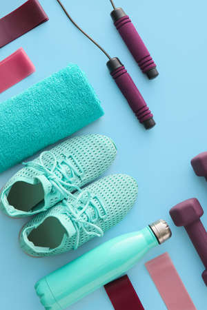 Set of sports equipment, towel and shoes on color background