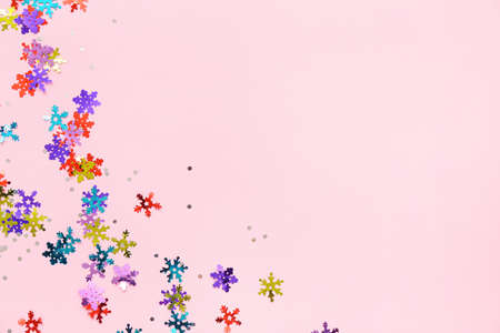Beautiful confetti in shape of snowflakes on pink background
