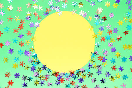 Blank card and confetti in shape of snowflakes on color background