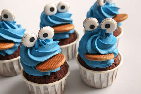 Tasty funny cupcakes for Halloween celebration on white background, closeup