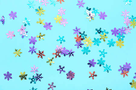 Colorful confetti in shape of snowflakes on color backgroundの写真素材