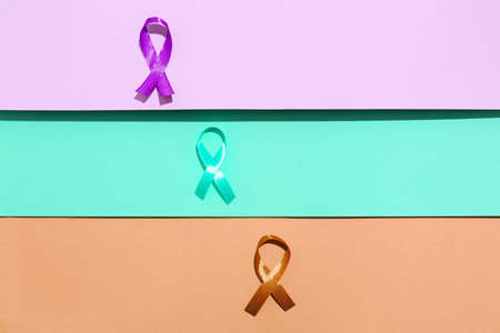 Different colorful awareness ribbons on color background. World Cancer Day