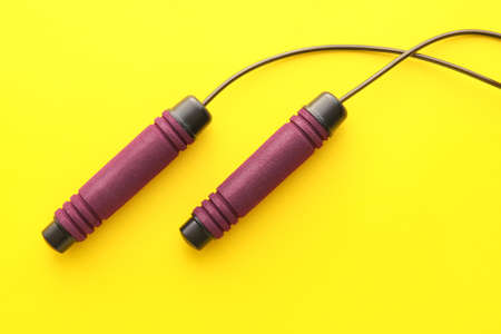 Stylish skipping rope on yellow background